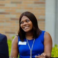 A group of three people sitting down talking with each other.